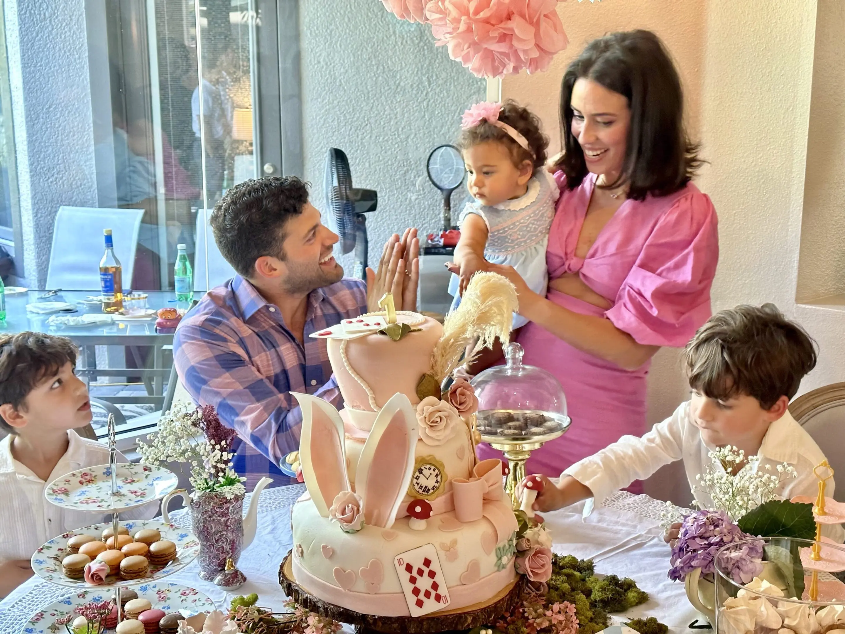 A family sitting at the table with a cake.